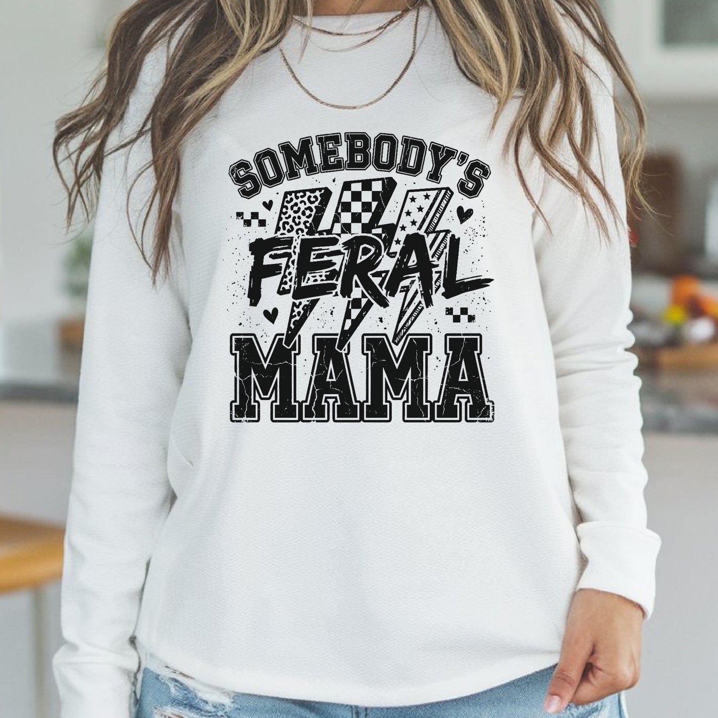 Funny mama graphic featuring the phrase Somebody's Feral Mama with distressed varsity lettering, lightning bolts, checkerboard accents, leopard print details, and grunge black typography