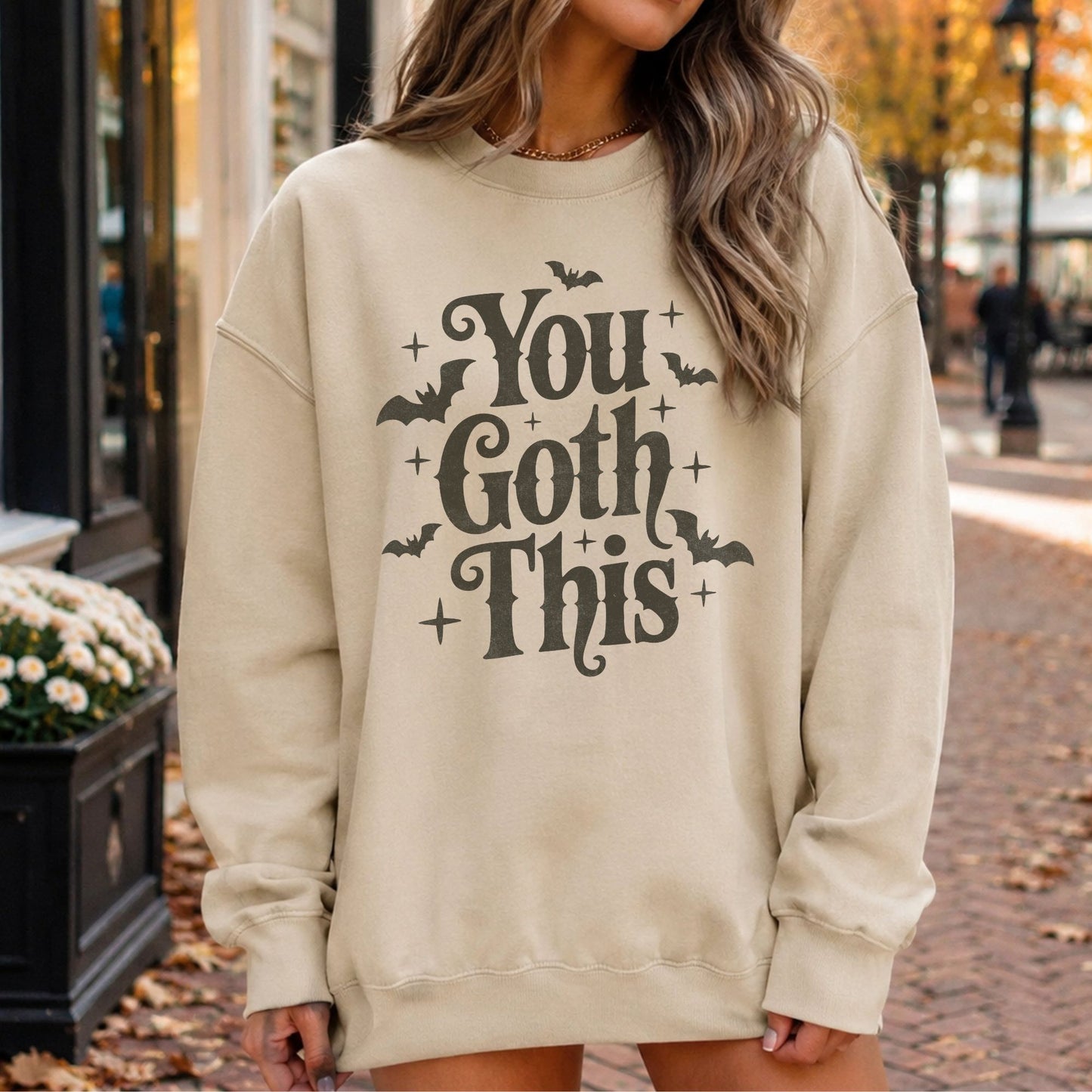 You Goth This Halloween DTF transfer featuring large distressed dark gray retro lettering surrounded by flying bats and sparkling star accents on a cream sweatshirt mockup.