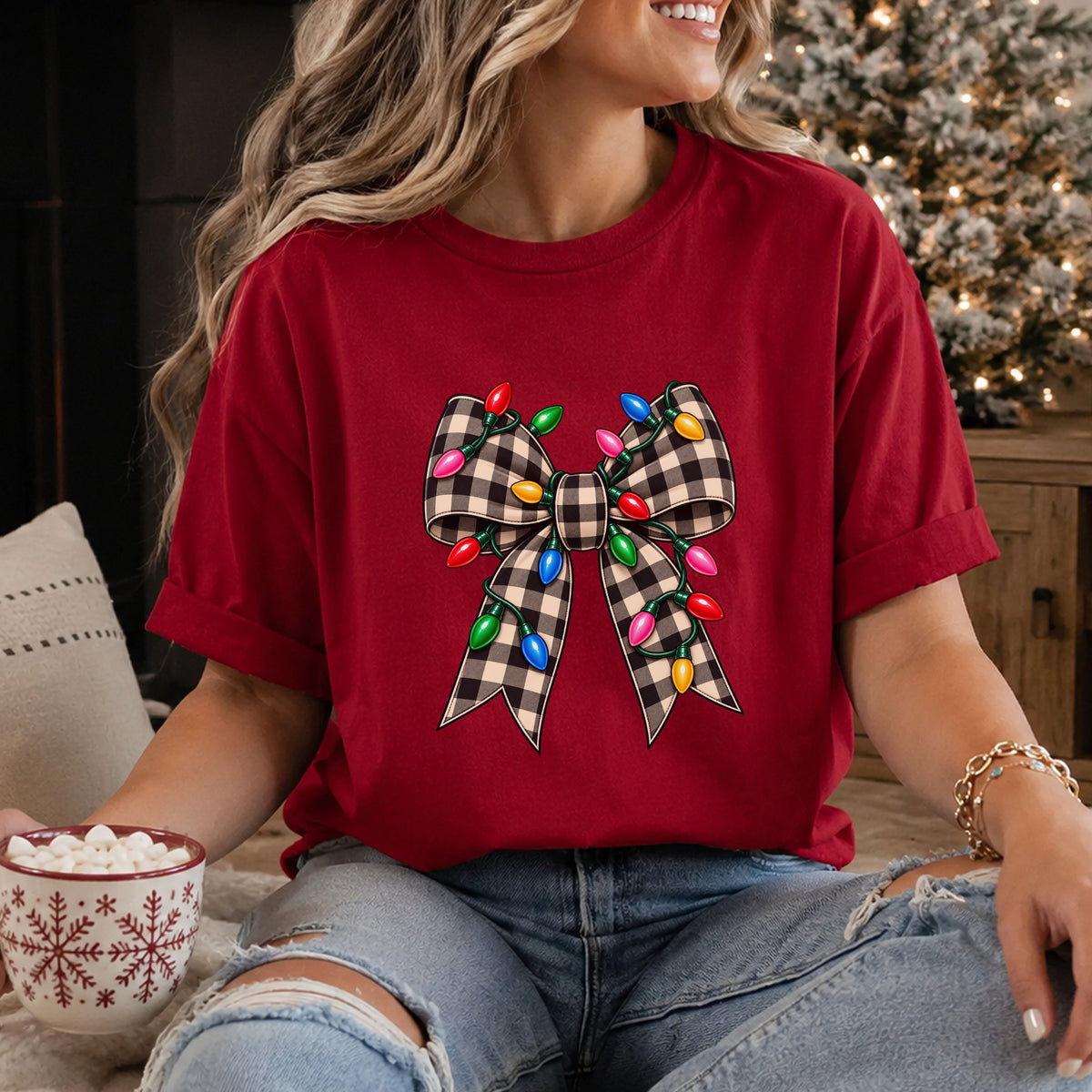 Black and tan buffalo check ribbon bow with long tails, wrapped in green wire Christmas lights with glossy red, pink, blue, green and yellow bulbs.