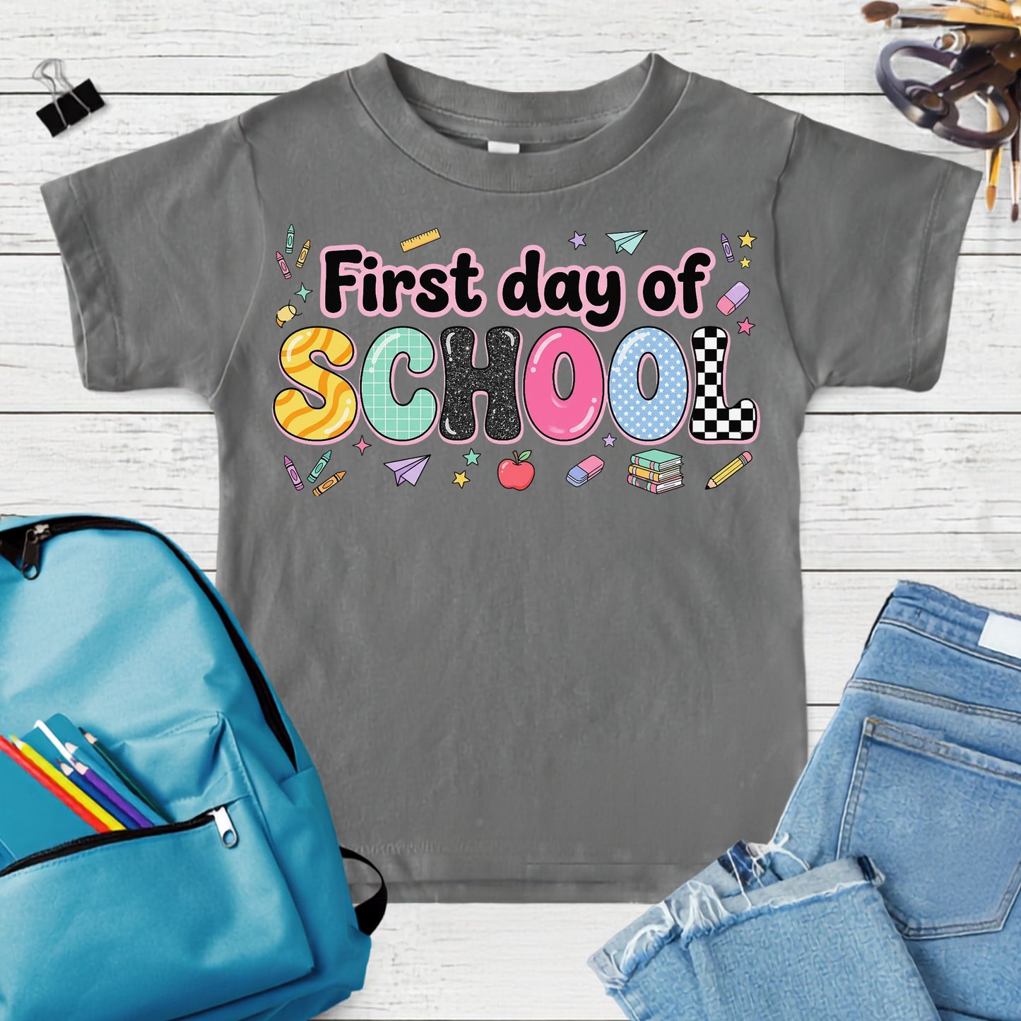 Coquette first day of school design featuring colorful patterned letters with school supplies, books, apple, paper airplane, crayons, and retro classroom icons.