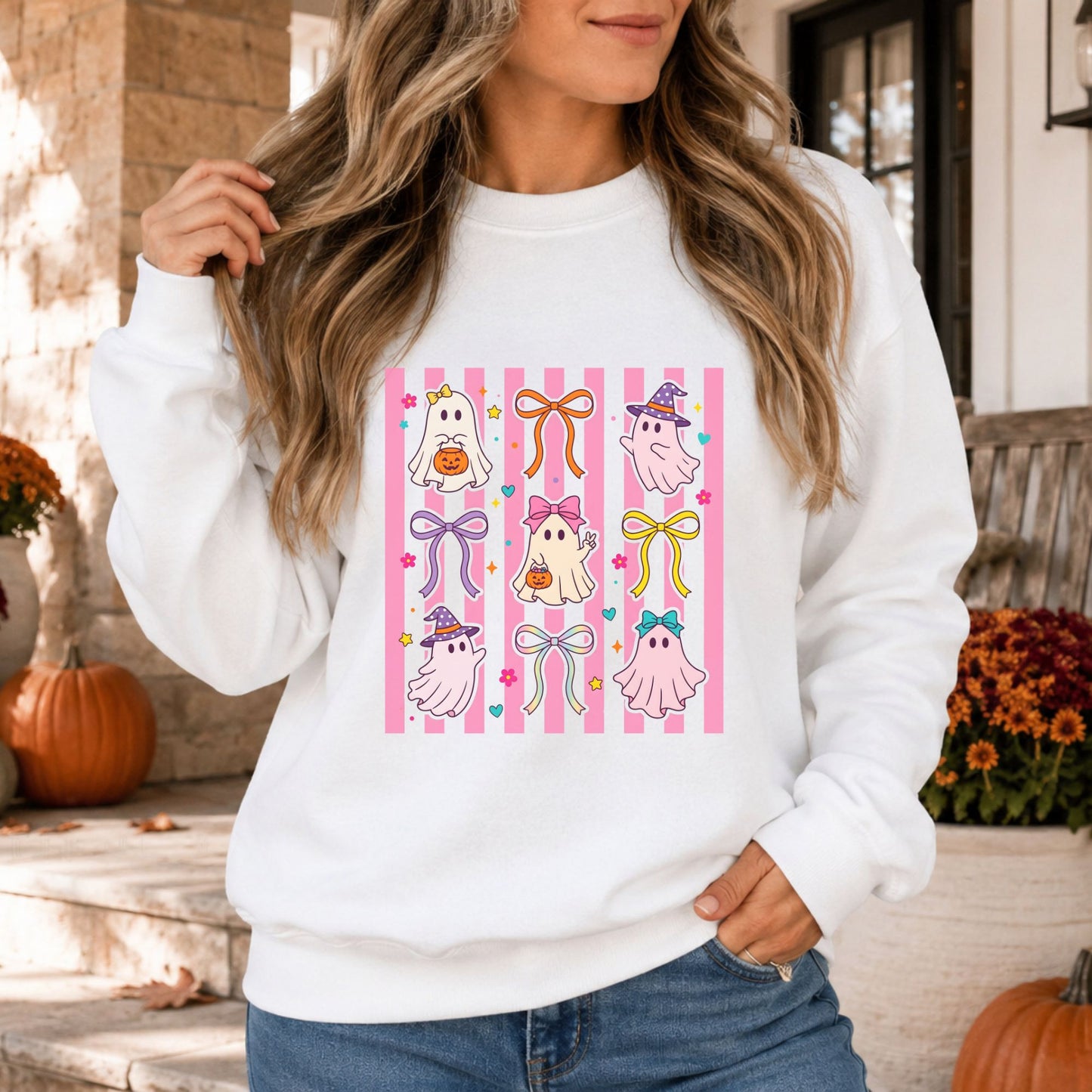 Coquette Halloween DTF transfer featuring cute pink and white ghosts, colorful ribbon bows, witch hats, pumpkin pails, hearts and flowers over a pink striped background on a white sweatshirt mockup.