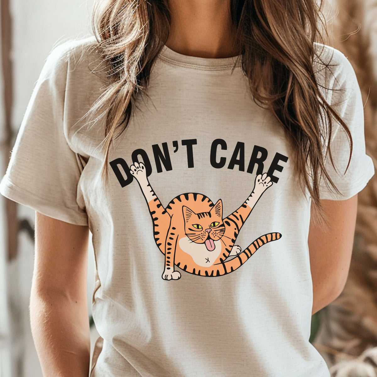Don't Care funny orange cat DTF transfer featuring a chaotic orange tabby cat with legs stretched in the air, tongue out, and a silly playful expression for cat lover shirts and sweatshirts.