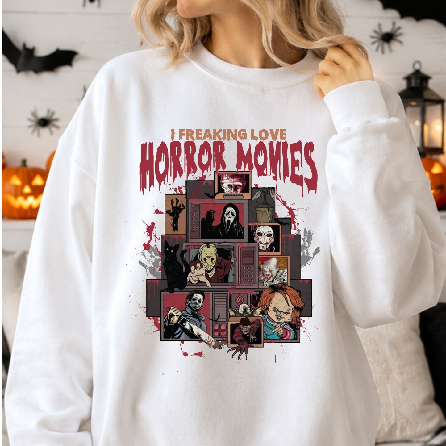 I Freaking Love Horror Movies DTF transfer featuring a collage of classic slasher and horror villain figures displayed across stacked vintage televisions with red blood-splatter accents on a white sweatshirt mockup.
