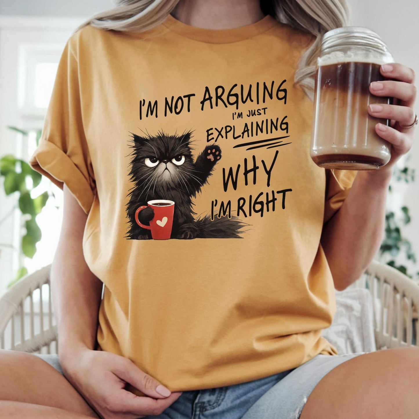 Funny black grumpy cat holding a coffee mug with the sarcastic quote I'm Not Arguing I'm Just Explaining Why I'm Right, humorous cat lover graphic perfect for coffee drinkers, introverts, and sarcastic women