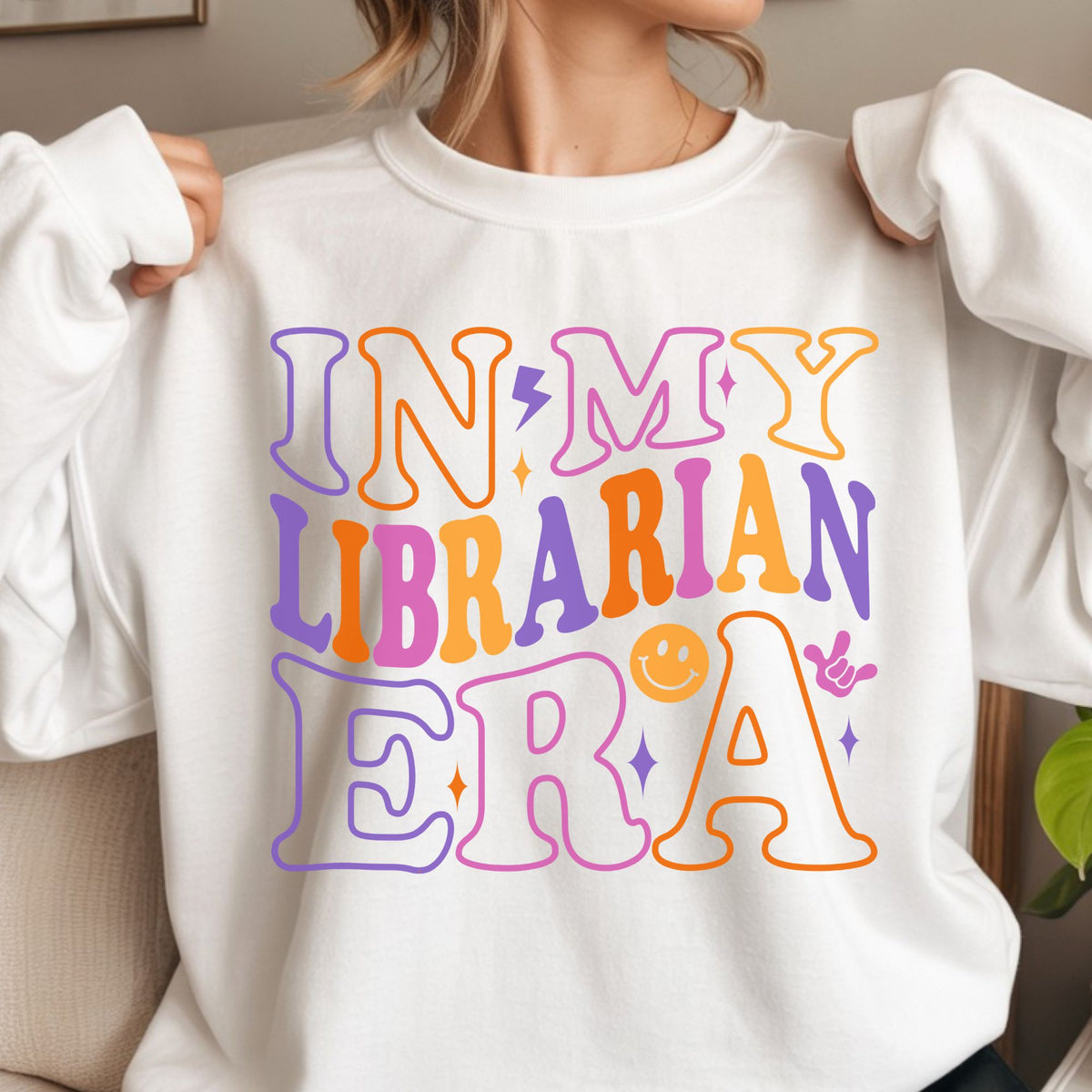 In My Librarian Era design featuring oversized retro lettering in purple, orange, pink, and yellow with a lightning bolt, smiley face, sparkles, and playful library staff style.
