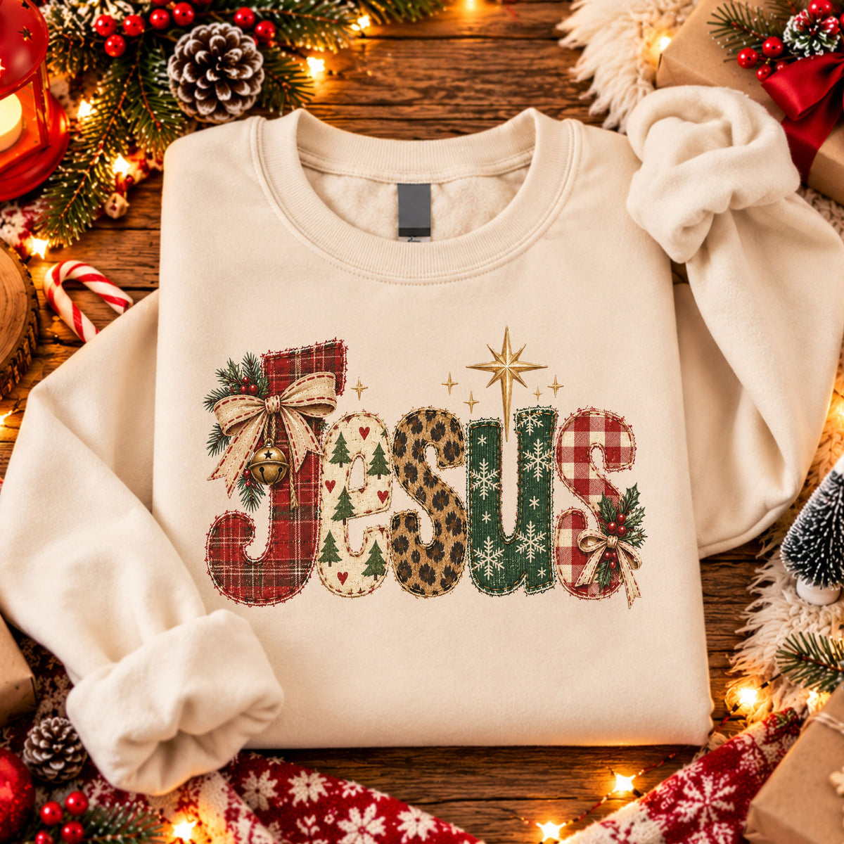 “Jesus” in faux stitched patchwork letters with red plaid, Christmas trees, leopard print, green snowflakes and red gingham, accented by bows, a bell and gold star.