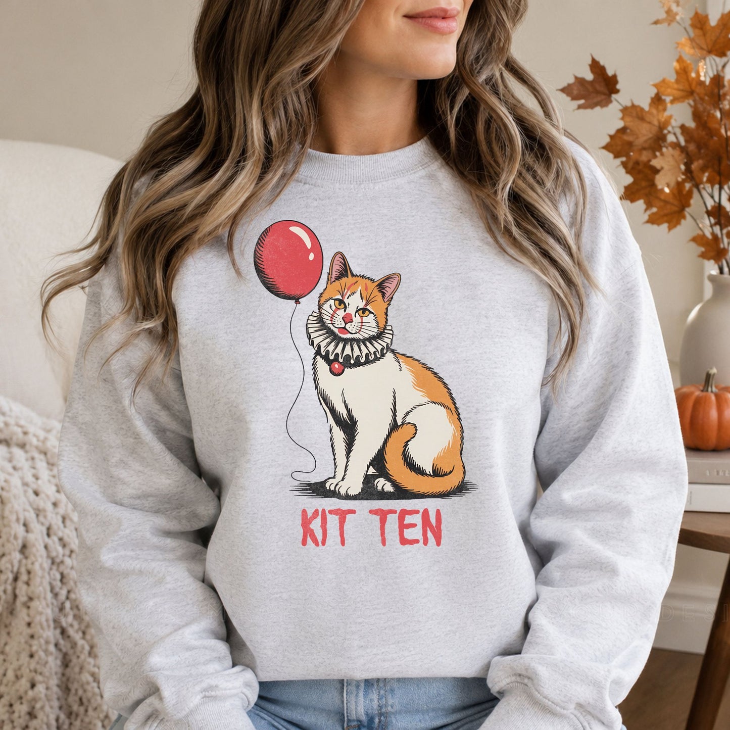 Kit Ten Halloween DTF transfer featuring an orange-and-white cat wearing a vintage ruffled clown collar while holding a red balloon, with distressed red lettering on a light gray sweatshirt mockup.