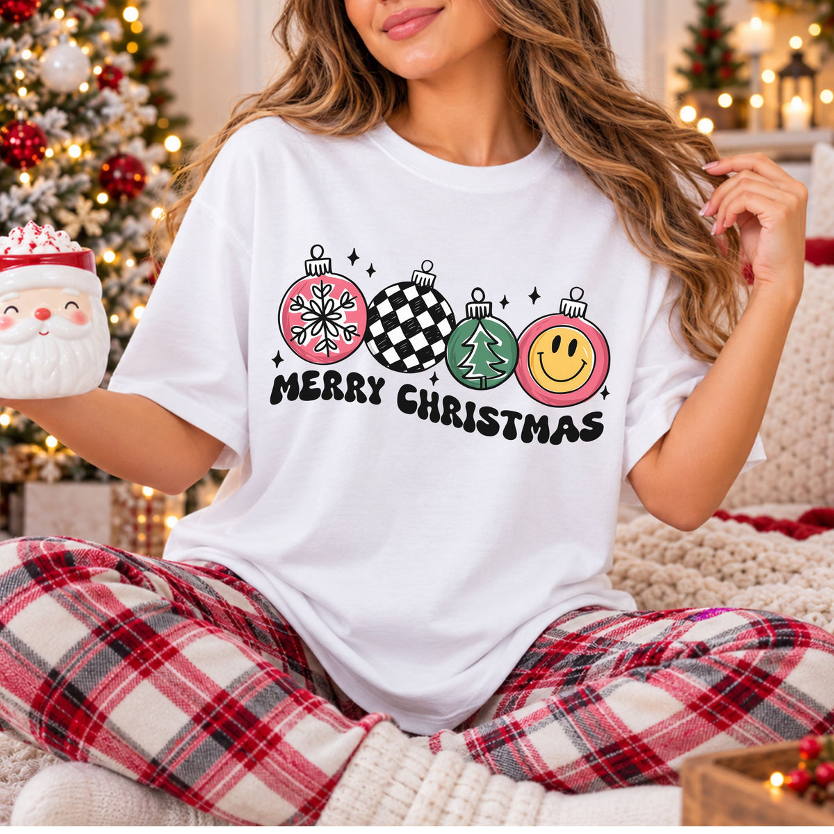 “Merry Christmas” in black bubble lettering beneath four ornaments featuring a snowflake, black and white checks, a green tree and a yellow smiley face, with pink accents and black stars.