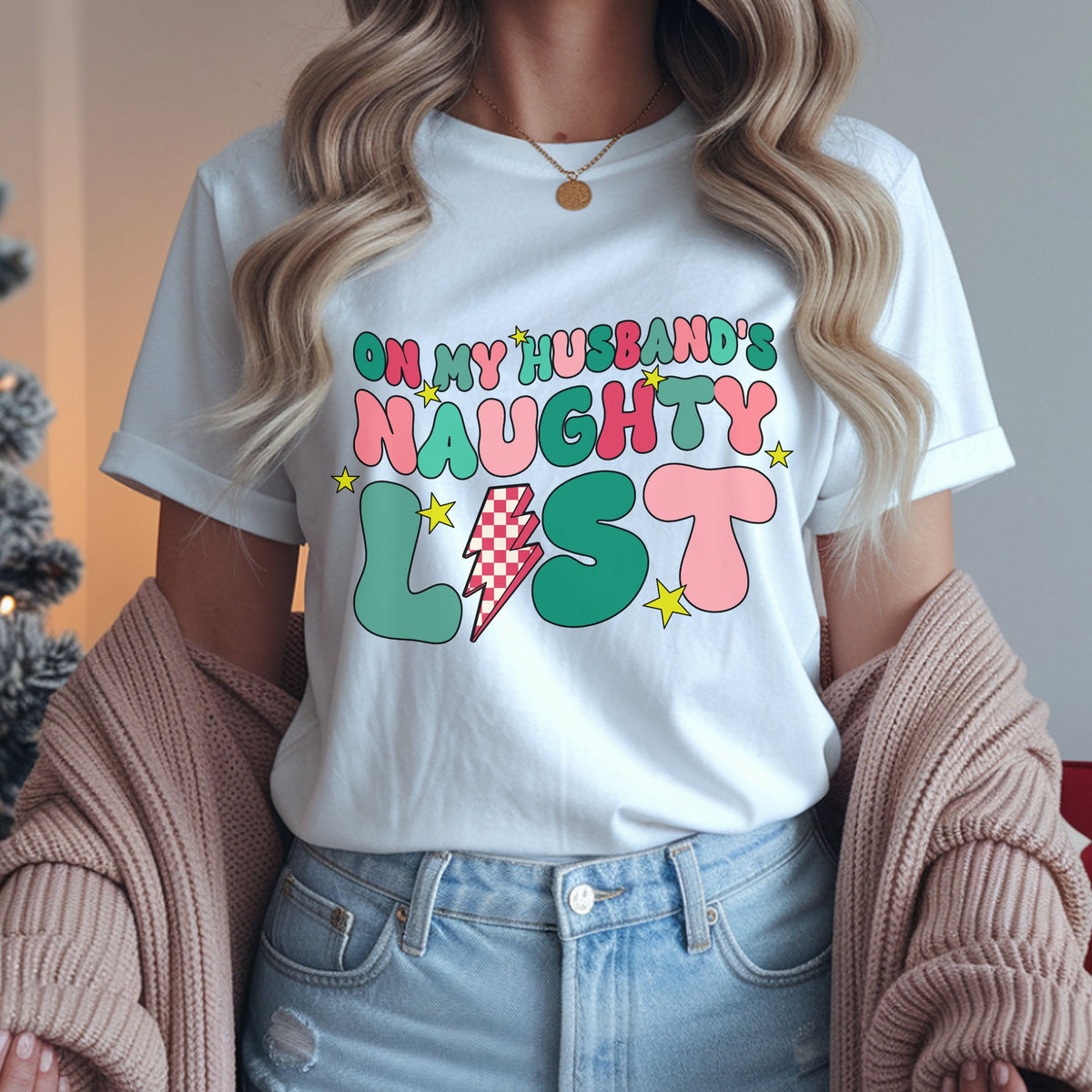 “On My Husband’s Naughty List” in pink and green retro bubble letters, with a red and cream checkered lightning bolt replacing the I in “List” and yellow stars.