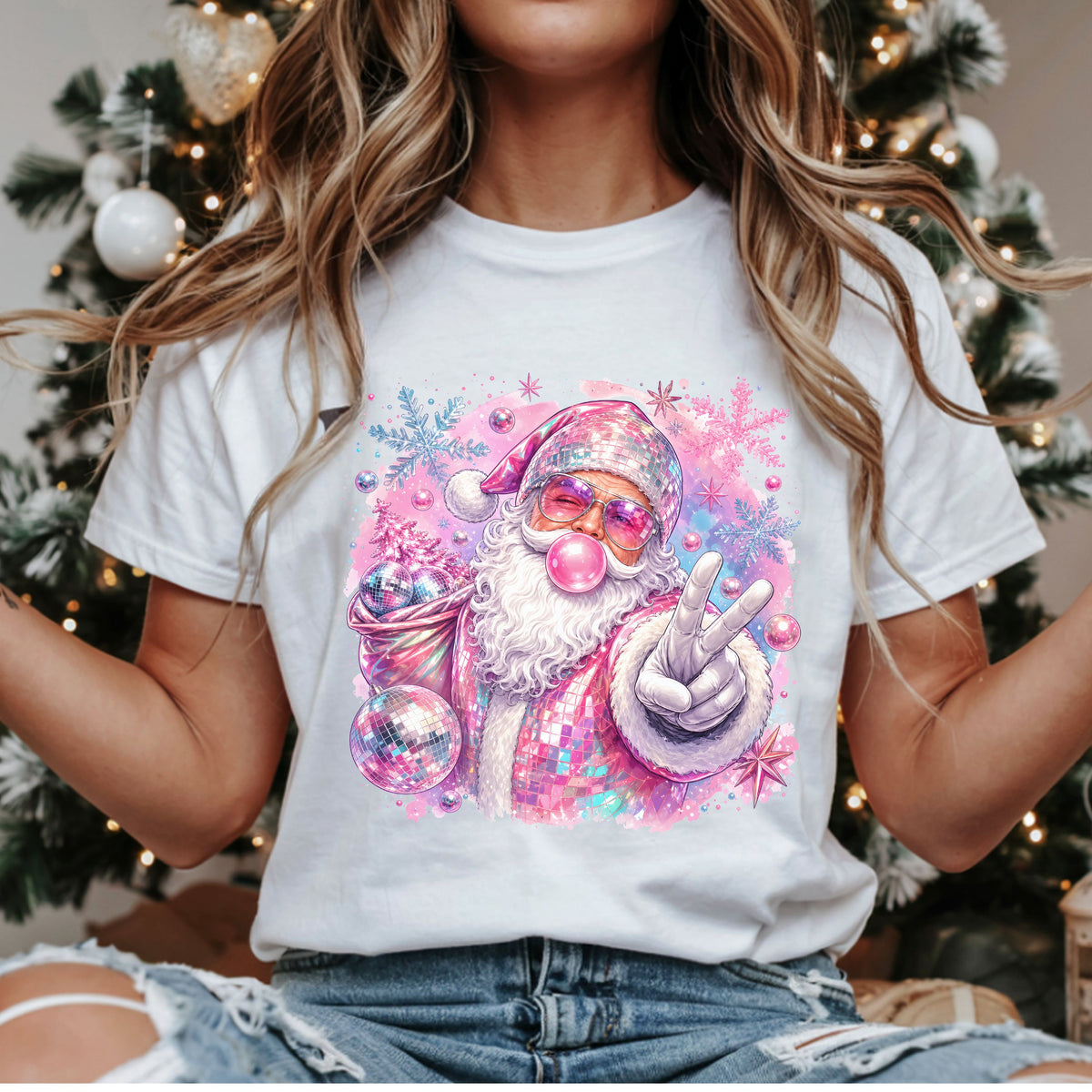 Pink disco Santa Christmas DTF transfer with bubblegum, a peace sign, mirrored pink suit, purple sunglasses and a sack of disco balls surrounded by pastel snowflakes.
