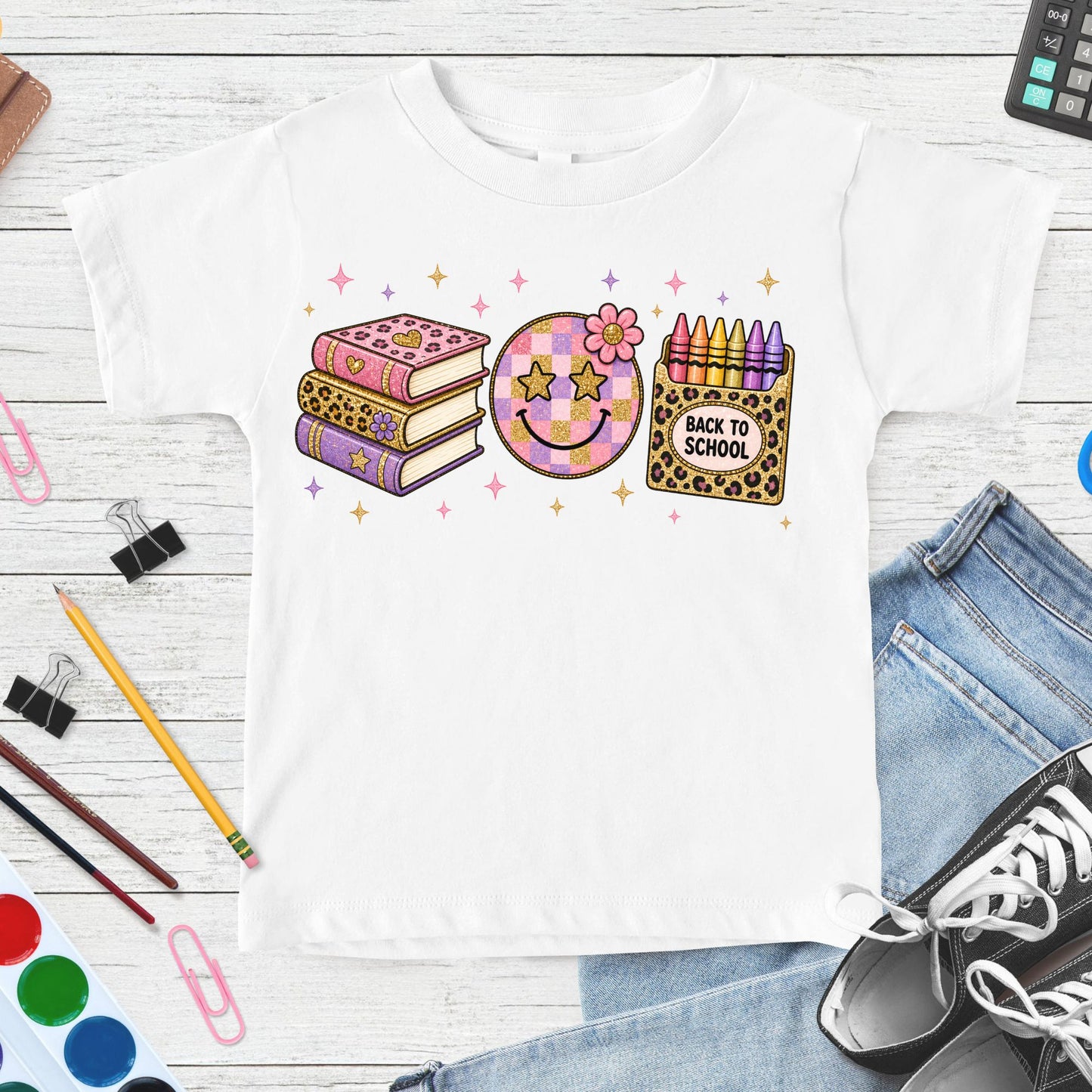 Pink leopard back-to-school design featuring stacked books, a checkerboard smiley face, colorful crayons, flowers, sparkles, and playful classroom accents.