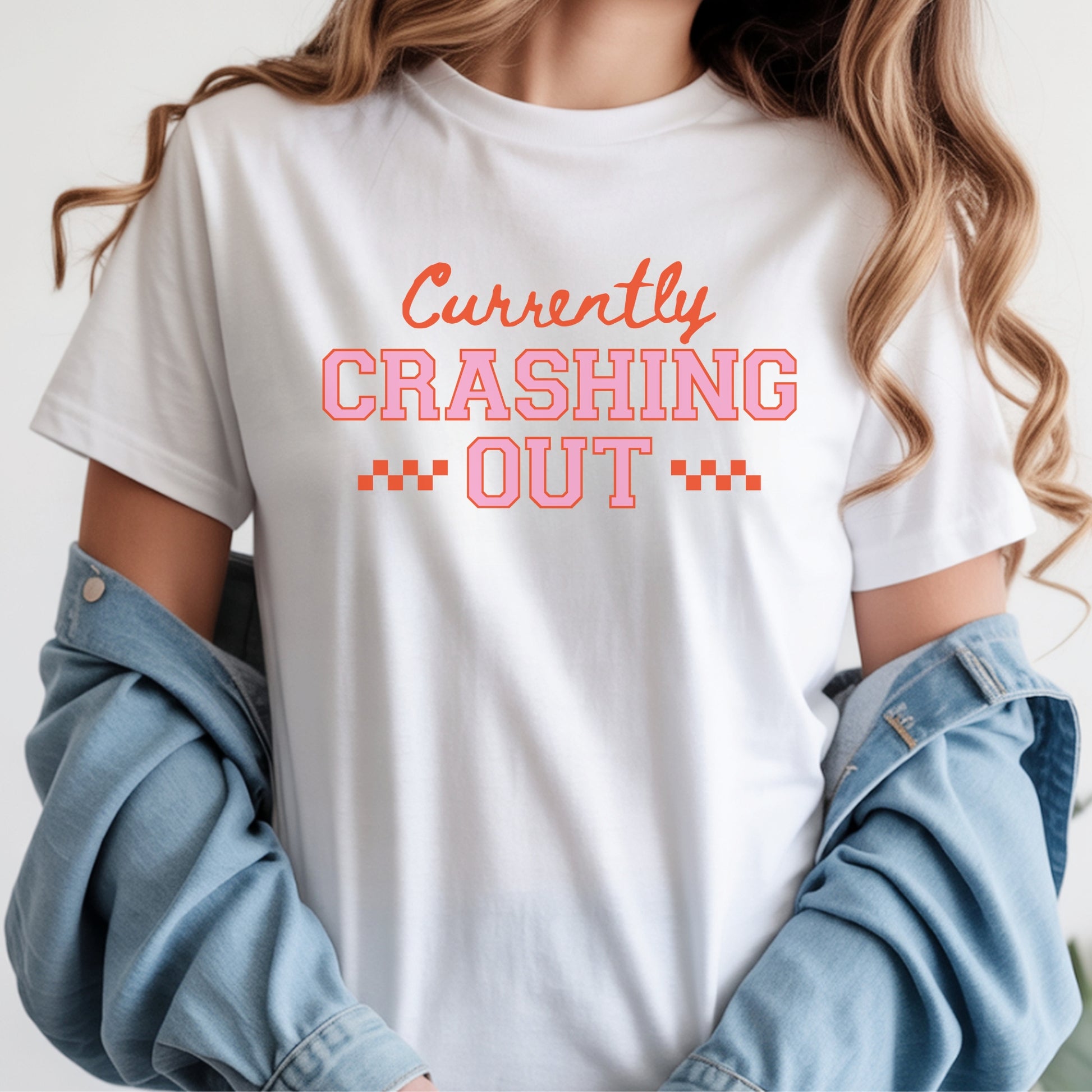 Funny Currently Crashing Out graphic featuring retro varsity lettering and trendy social media humor typography in orange and pink
