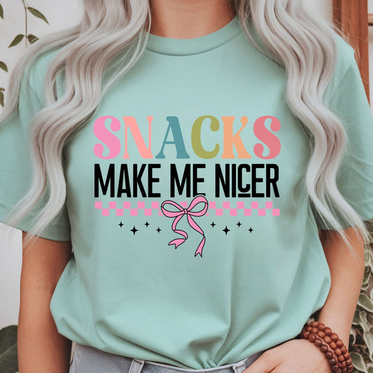 Funny Snacks Make Me Nicer graphic with colorful retro lettering, pink bow, and checker accents
