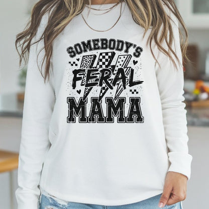 Funny mama graphic featuring the phrase Somebody's Feral Mama with distressed varsity lettering, lightning bolts, checkerboard accents, leopard print details, and grunge black typography