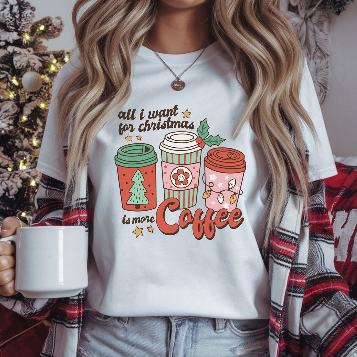 “All I want for Christmas is more Coffee” with three retro takeaway cups in red, mint and pink, decorated with a Christmas tree, smiley flower and string lights.