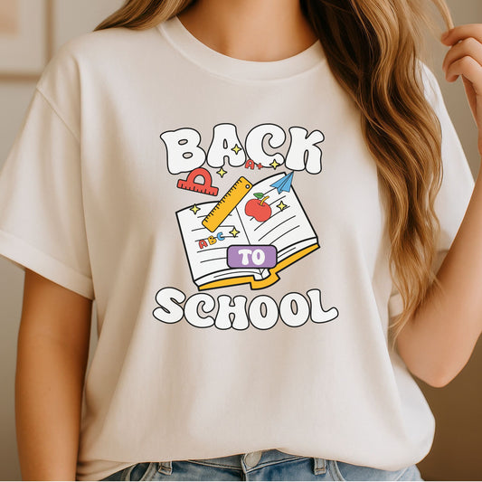 Back to School DTF transfer featuring an open book, ruler, apple, paper airplane, protractor, ABC letters, and colorful classroom supplies.