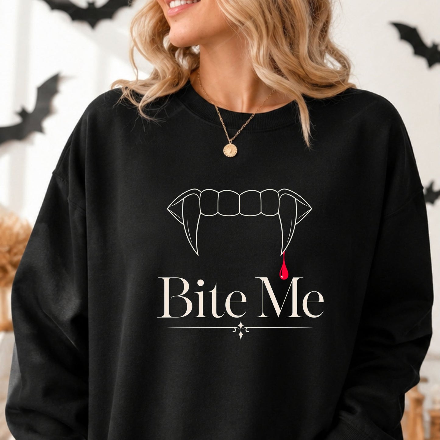 Bite Me Halloween DTF transfer featuring minimalist white vampire fangs with a single red blood drop and elegant gothic lettering, displayed on a black sweatshirt mockup.