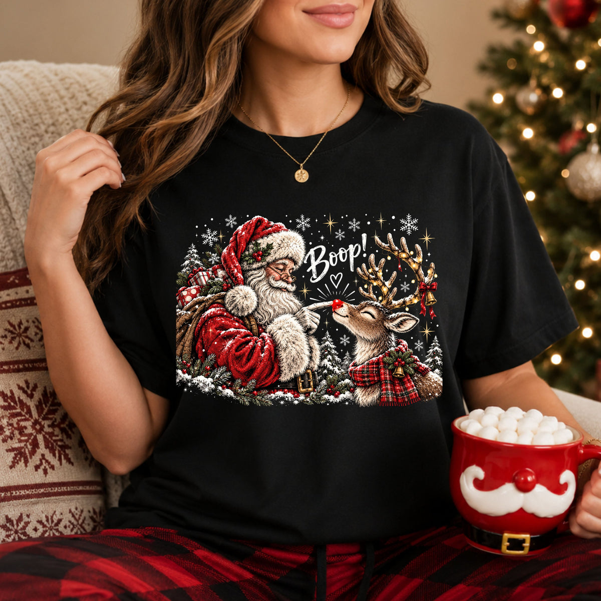 “Boop!” above Santa touching a reindeer’s red nose, surrounded by snowy trees and snowflakes. The reindeer wears a red plaid scarf and has lights, a bow and bells on its antlers.