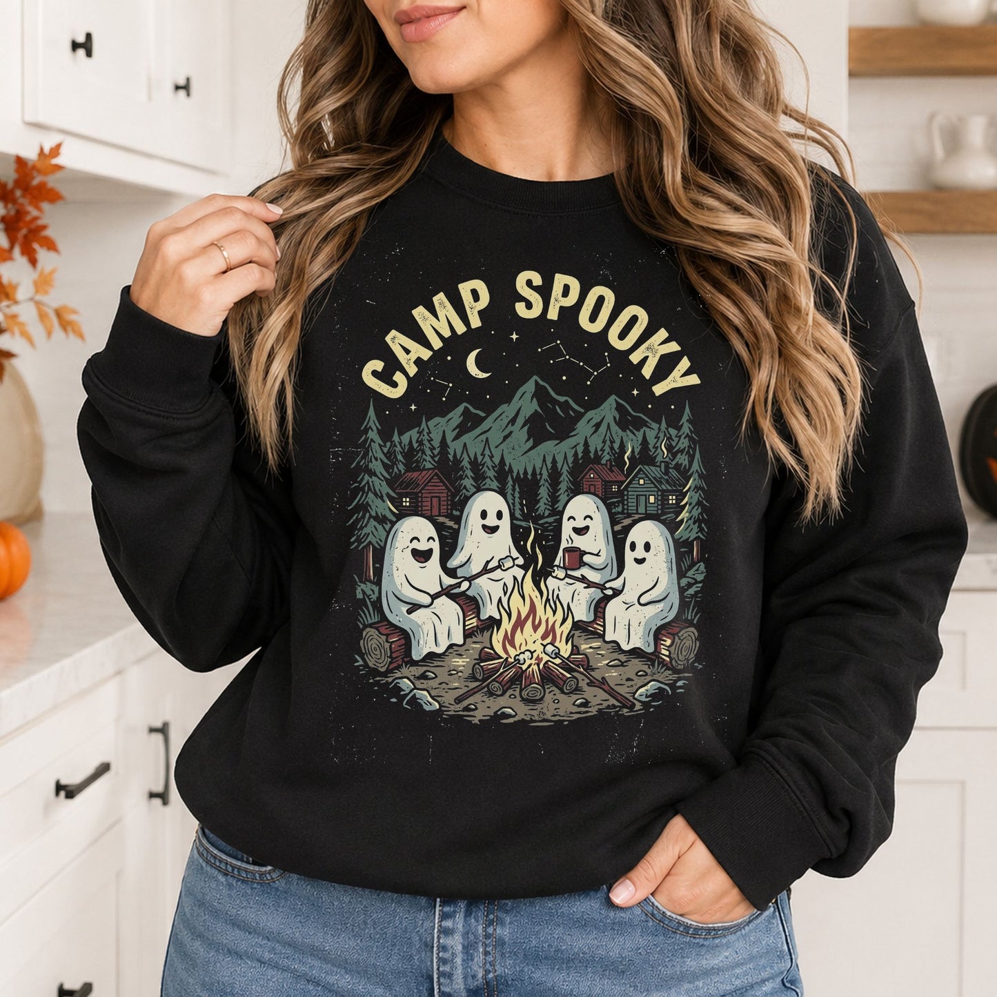 Black sweatshirt mockup featuring cute ghosts sitting around a campfire with the phrase Camp Spooky in a spooky outdoor camping design.