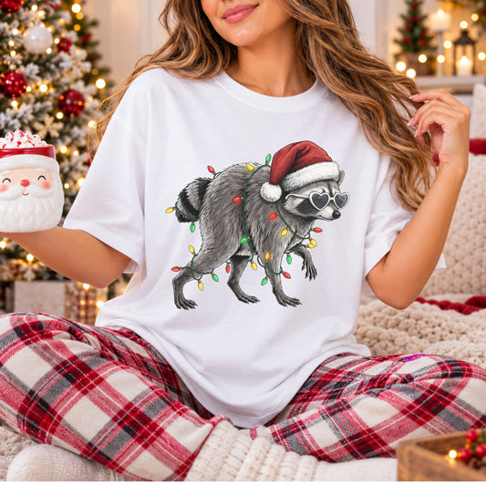 Gray raccoon wearing a red Santa hat and white heart-shaped sunglasses, wrapped in red, yellow and green Christmas lights, on a Christmas DTF transfer.