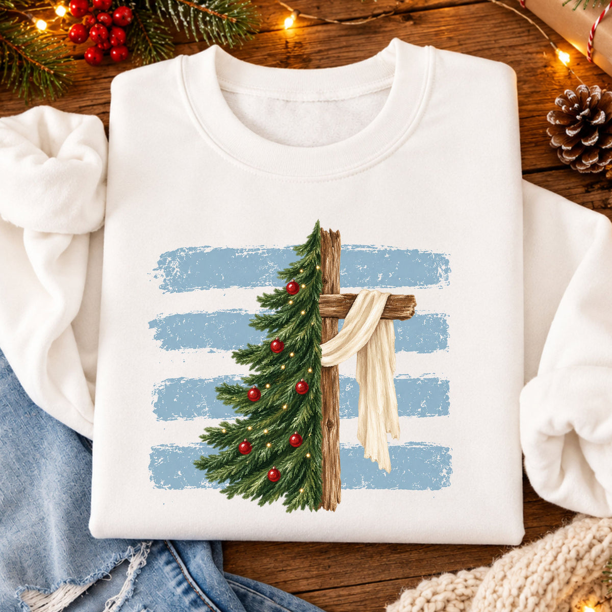 A Christmas tree with red ornaments and warm lights blends into a wooden cross draped with cream cloth, set against pale blue brushstrokes.
