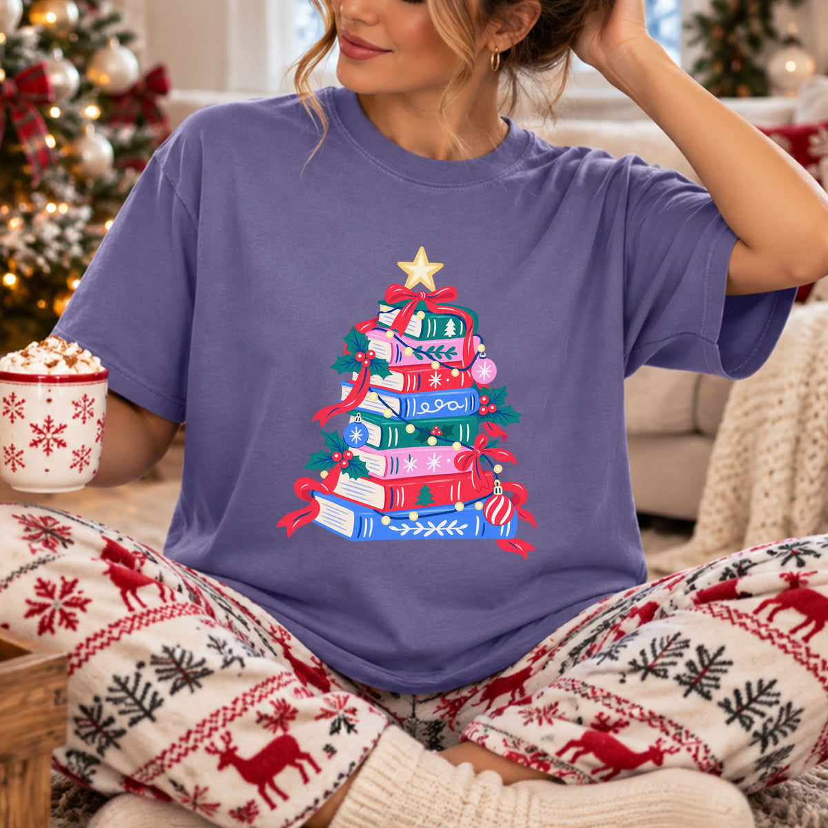 Christmas tree made from stacked teal, pink, red and blue books, decorated with red bows, yellow string lights, holly, ornaments and a yellow star.