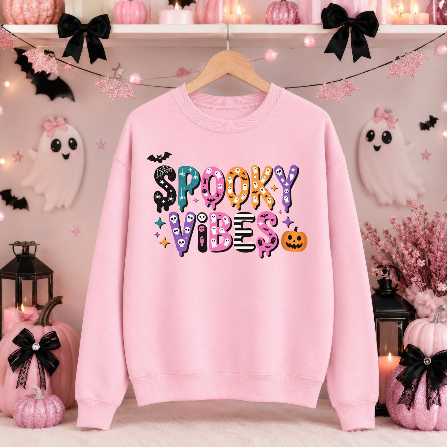 Colorful Spooky Vibes Halloween DTF transfer featuring playful patterned lettering decorated with ghosts, skulls, bats, spiderwebs, stars and an orange jack-o-lantern on a pink sweatshirt mockup.