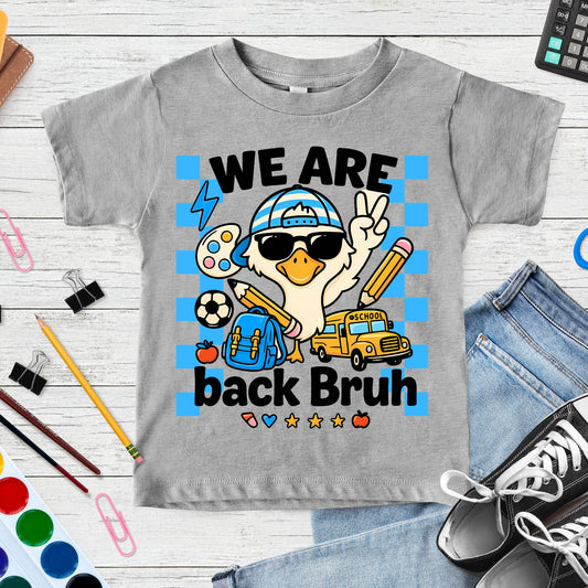 We Are Back Bruh back-to-school design featuring a cool goose wearing sunglasses and a striped cap with a backpack, pencils, school bus, soccer ball, paint palette, apple, and blue checkerboard accents.