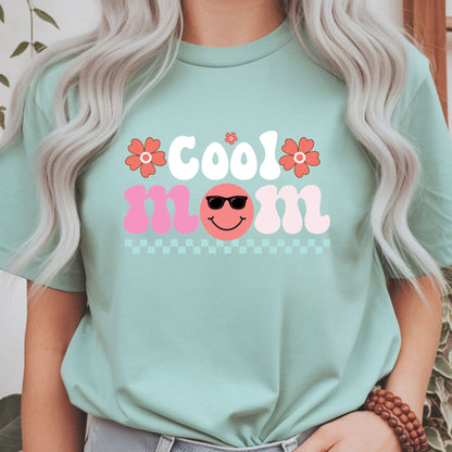 Retro "Cool Mom" design featuring a smiling face with sunglasses, coral flowers, and a pastel checkerboard accent. Perfect for cool moms, trendy moms, Mother's Day gifts, retro lovers, and cute aesthetic graphic tees and hoodies.
