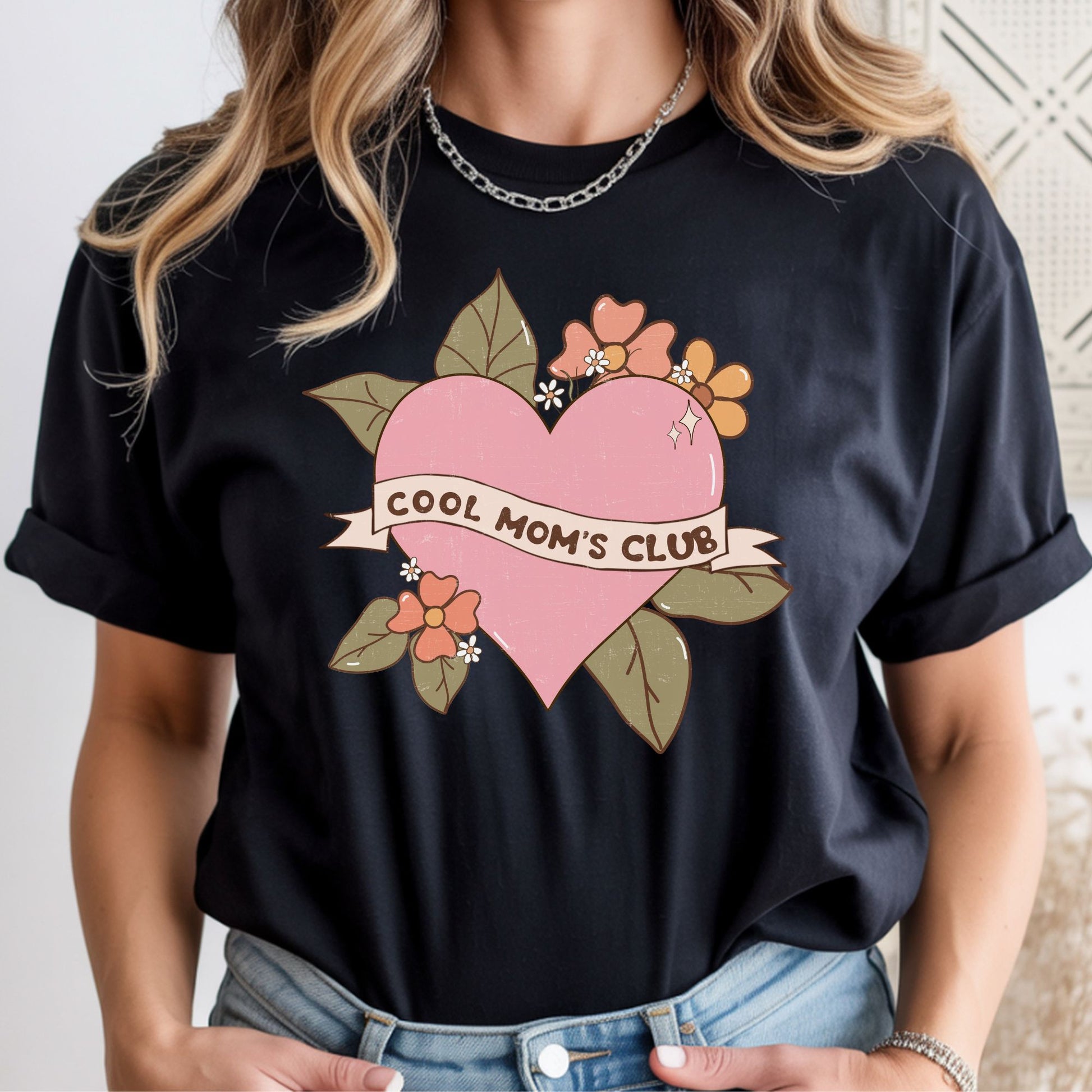 Retro floral heart design featuring the phrase "Cool Mom's Club" on a ribbon banner with vintage-inspired flowers and leaves. Perfect for cool moms, Mother's Day gifts, trendy moms, and retro aesthetic graphic tees and hoodies.
