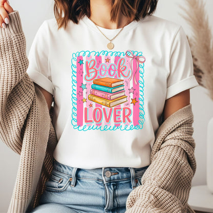 Cute coquette book lover graphic featuring a stack of colorful books, pink striped background, teal doodle border, stars, and bow accents for trendy graphic tees, hoodies, and bookish apparel.

