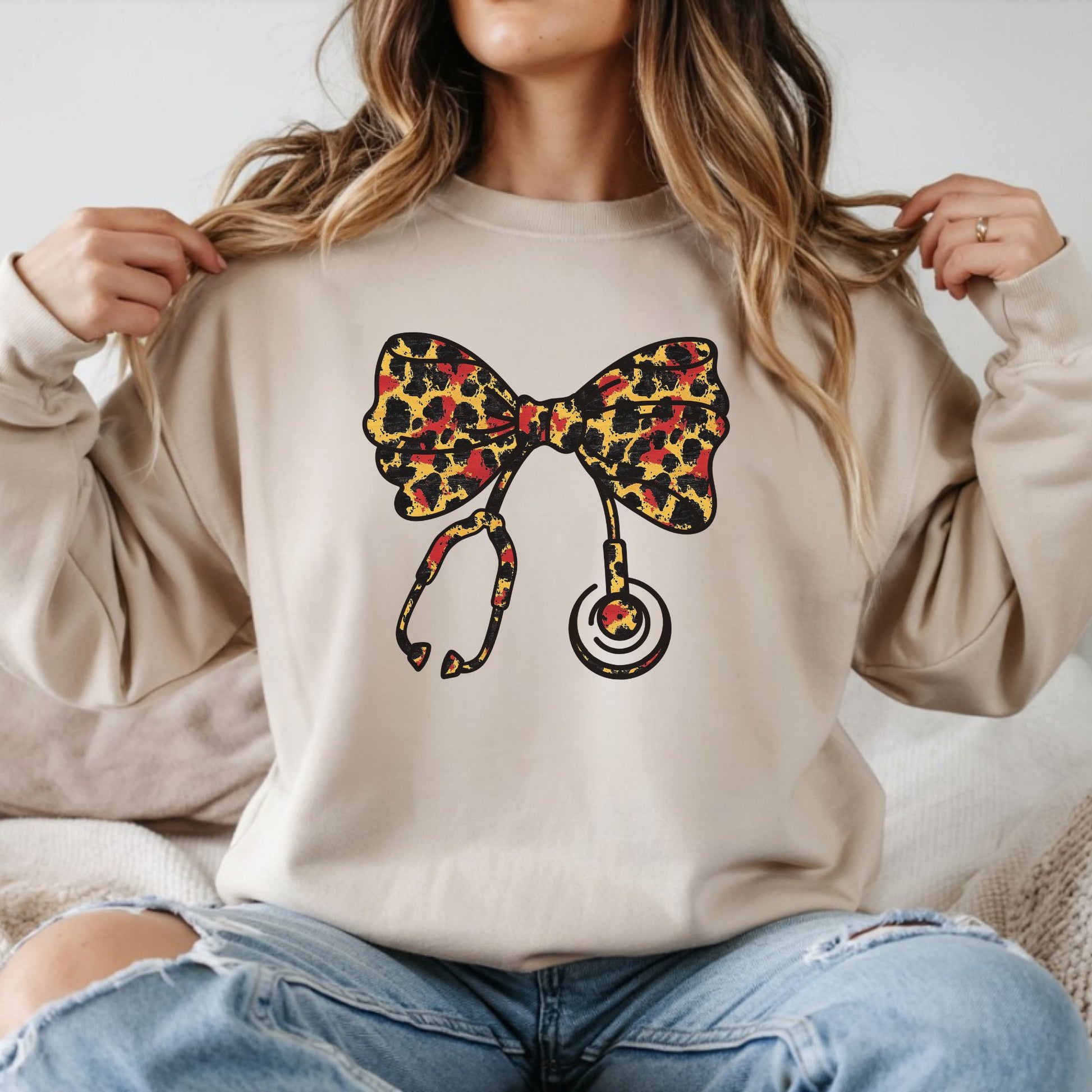 Coquette nurse leopard bow DTF transfer design on beige sweatshirt with stethoscope bow graphic