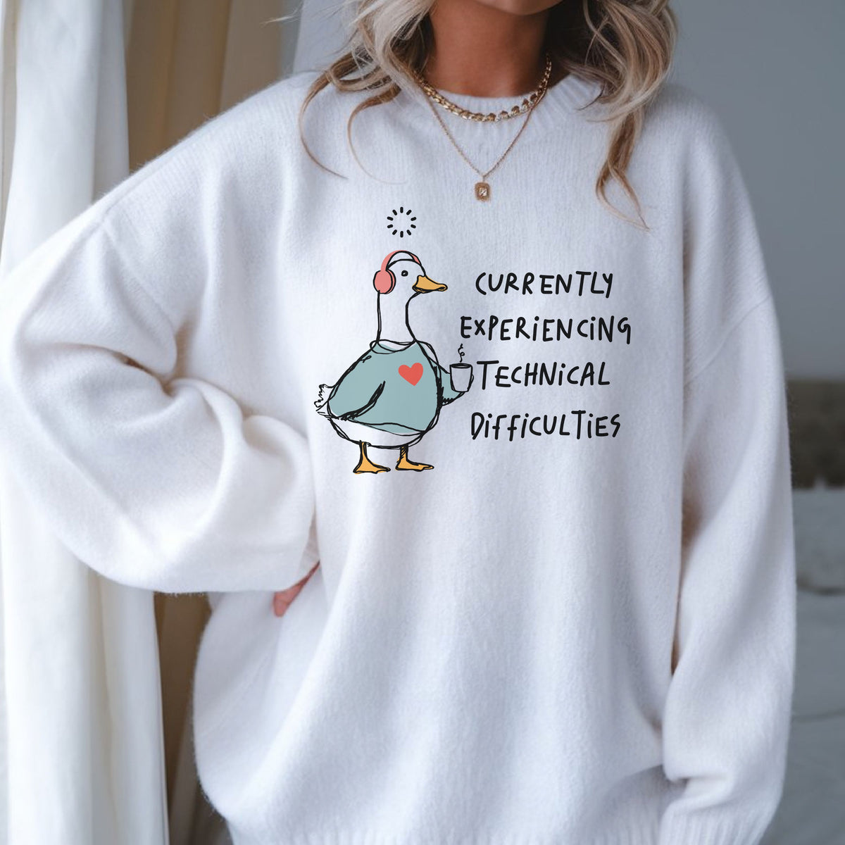 Currently Experiencing Technical Difficulties goose DTF transfer featuring a funny white goose wearing pink headphones, holding a coffee mug, and wearing a blue sweatshirt with a heart for sarcastic shirts, funny goose sweatshirts, tote bags, and quirky graphic apparel.
