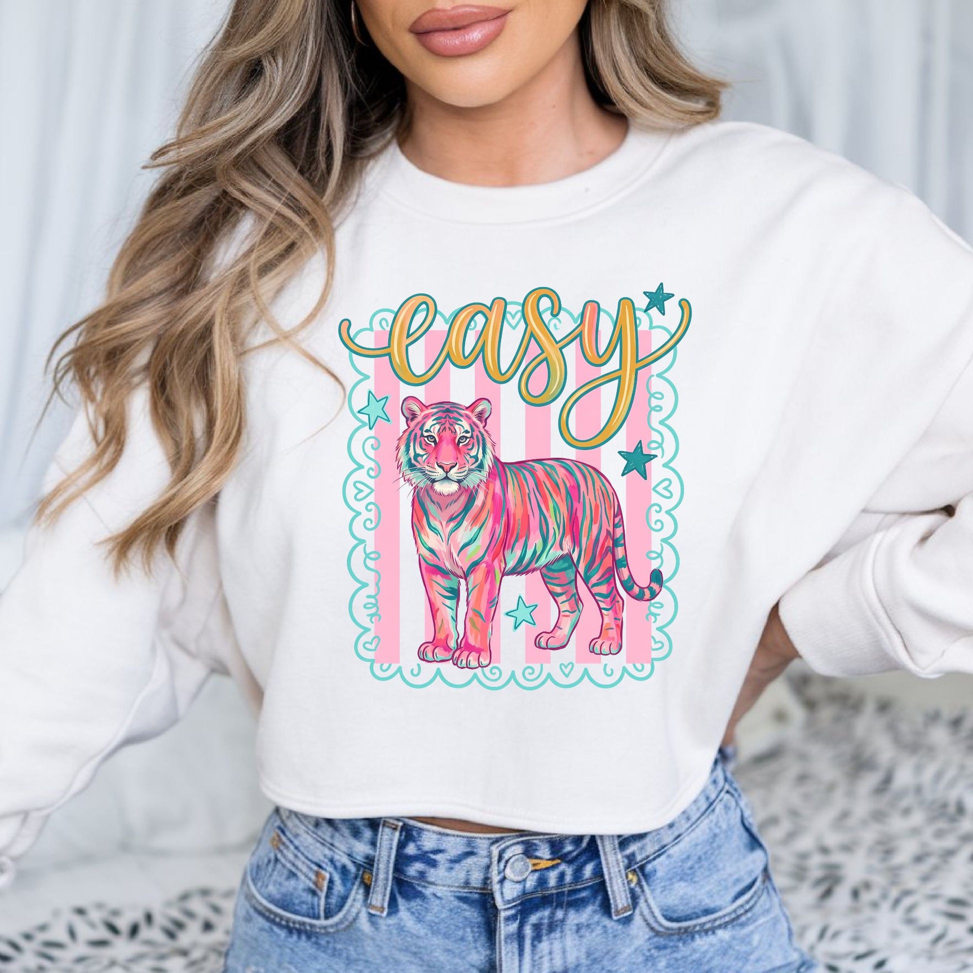 Colorful pink tiger graphic with Easy Tiger lettering, pastel stripes, stars, and coquette doodle border. Perfect for trendy graphic tees, western style, and maximalist fashion.

