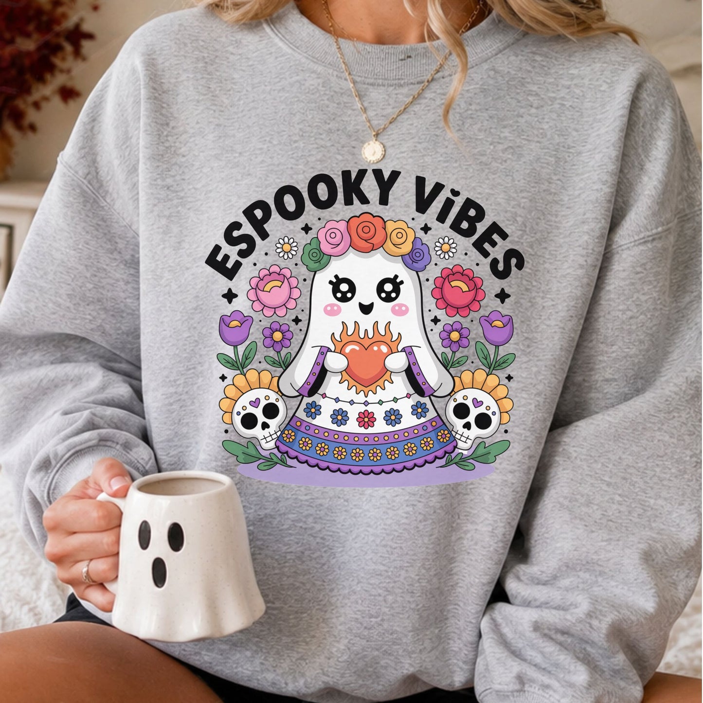 Espooky Vibes DTF transfer featuring a cute ghost in a colorful Día de los Muertos-inspired dress with a flower crown, flaming heart, sugar skulls and bright floral accents on a gray sweatshirt mockup.