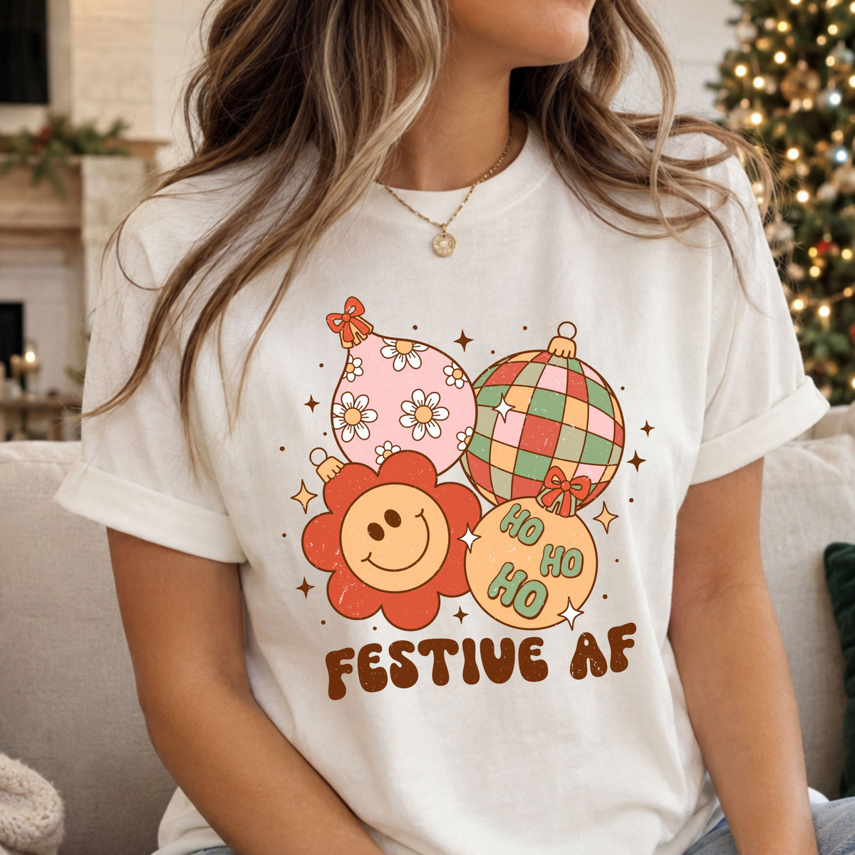 Festive AF beneath four Christmas ornaments: a pink floral teardrop, colorful disco ball, coral smiley flower and peach Ho Ho Ho bauble, surrounded by bows and starbursts.