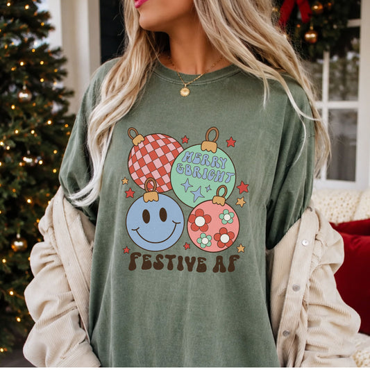 Christmas DTF transfer reading “Festive AF” and “Merry & Bright,” with pastel ornaments featuring pink and red checks, a blue smiley face and daisies.