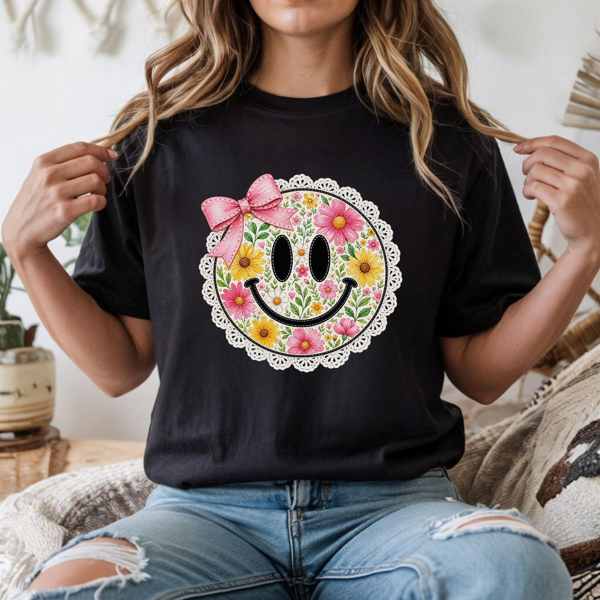 Floral smiley face DTF transfer featuring pink, yellow, and white flowers, green leaves, a large pink coquette bow, and a lace-style scalloped border for cute shirts, sweatshirts, tote bags, and feminine graphic apparel.