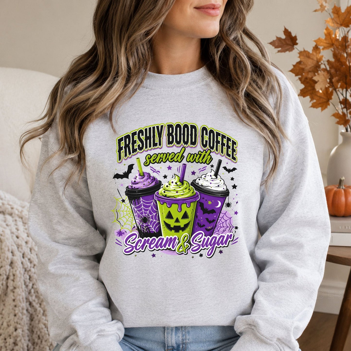 Ash gray sweatshirt mockup featuring the Freshly Bood Coffee served with Scream and Sugar Halloween DTF transfer in green, purple, black, and white.