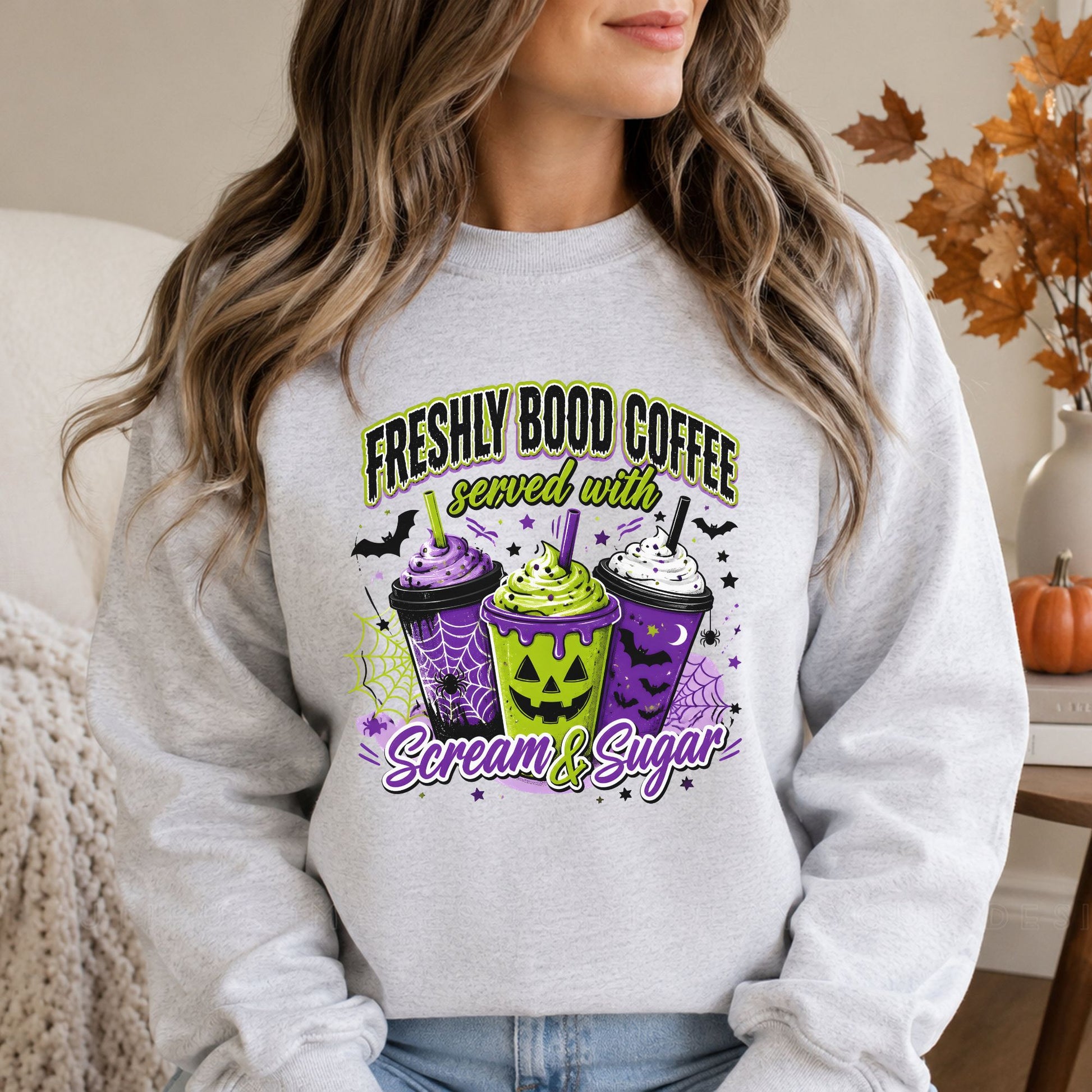Ash gray sweatshirt mockup featuring the Freshly Bood Coffee served with Scream and Sugar Halloween DTF transfer in green, purple, black, and white.