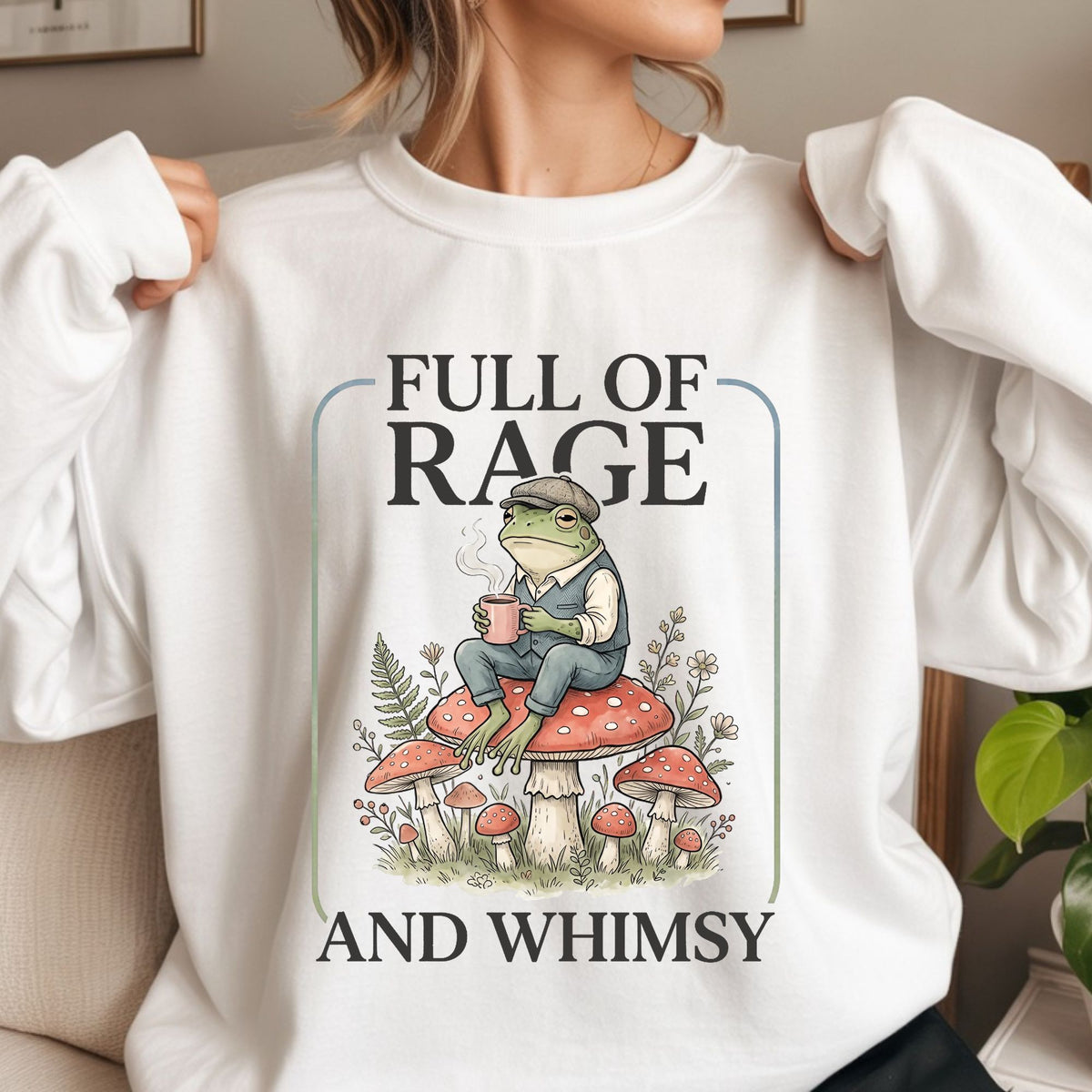 Full of Rage and Whimsy frog DTF transfer featuring a whimsical frog in a vest and cap sitting on red mushrooms with a steaming mug, surrounded by flowers and woodland greenery for cottagecore shirts, funny frog sweatshirts, tote bags, and whimsical graphic apparel.