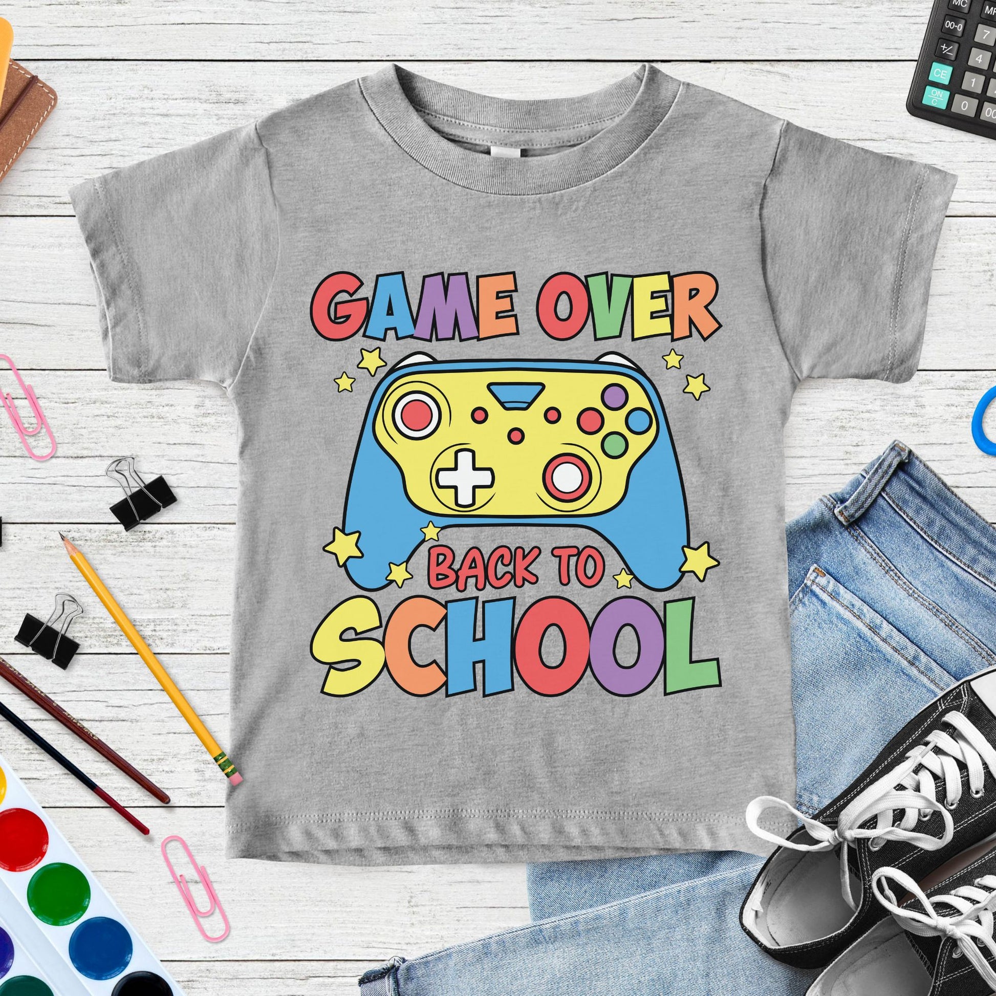 Game Over Back to School design featuring a colorful video game controller, stars, and bold retro lettering for gamer-themed toddler, kids, and youth shirts.