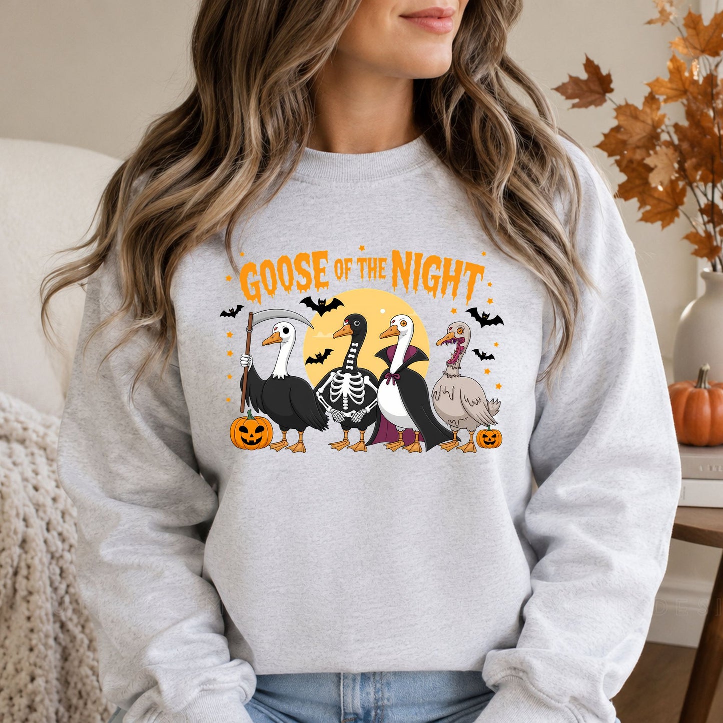 Funny Goose of the Night Halloween DTF transfer featuring four geese dressed in grim reaper, skeleton, vampire and zombie costumes with bats, pumpkins and a full moon on a gray sweatshirt mockup.