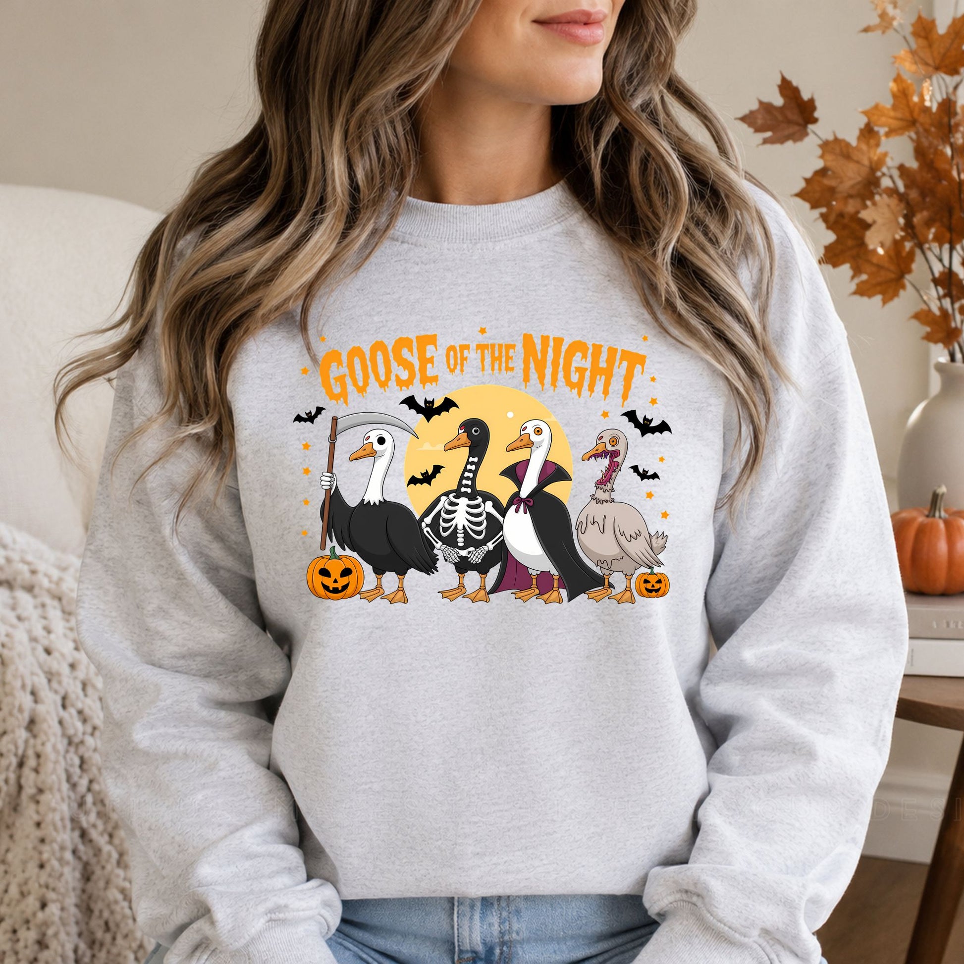 Funny Goose of the Night Halloween DTF transfer featuring four geese dressed in grim reaper, skeleton, vampire and zombie costumes with bats, pumpkins and a full moon on a gray sweatshirt mockup.