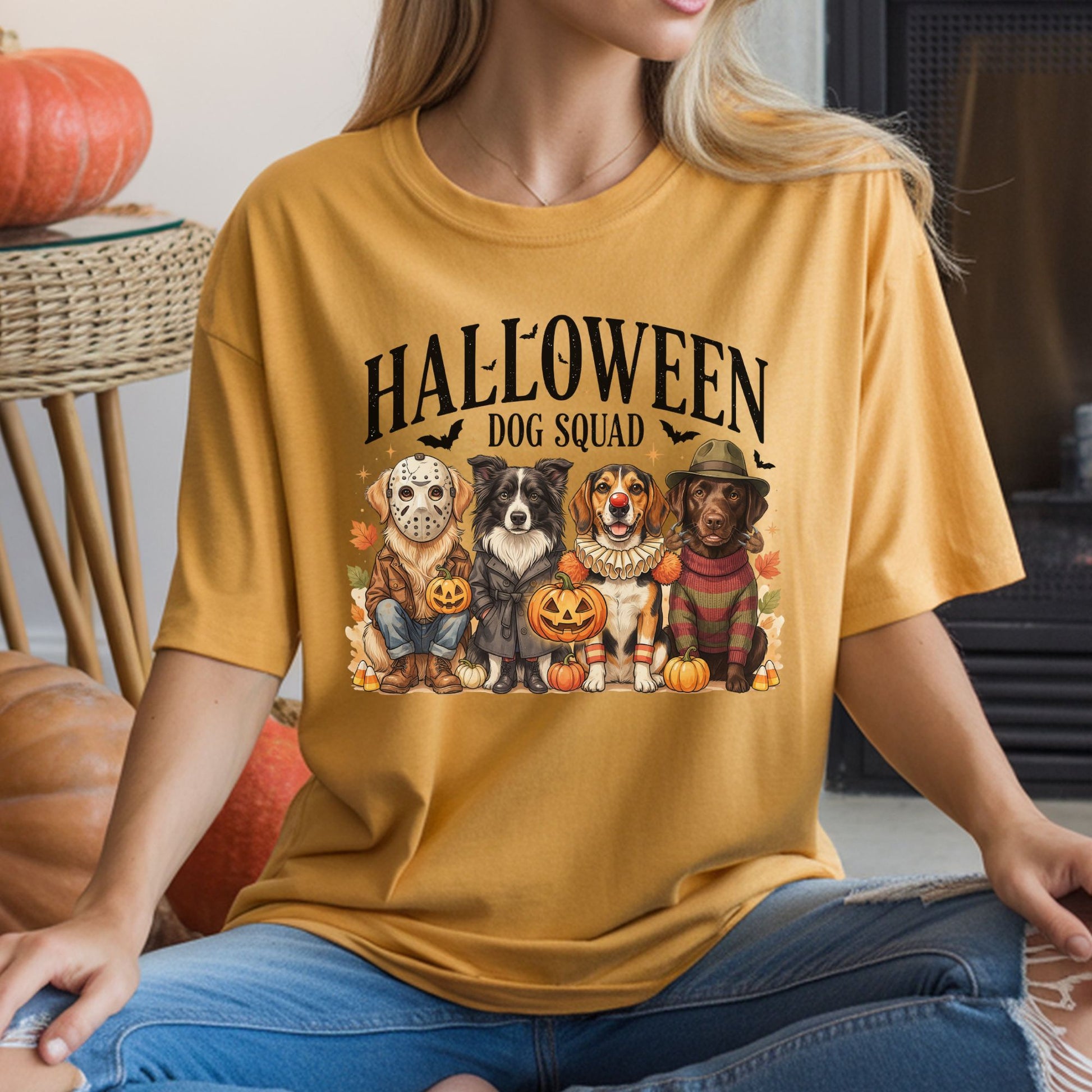Halloween Dog Squad DTF transfer featuring four realistic dogs dressed in classic horror movie-inspired costumes, including a hockey mask, dark raincoat, creepy clown outfit and striped sweater with fedora, surrounded by pumpkins, candy corn, bats and autumn leaves on a mustard T-shirt mockup.