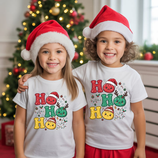 Ho Ho Ho Christmas DTF transfer with smiling red, green and yellow dumplings, a Santa hat, reindeer antlers, knit hat, string lights and faux glitter details.