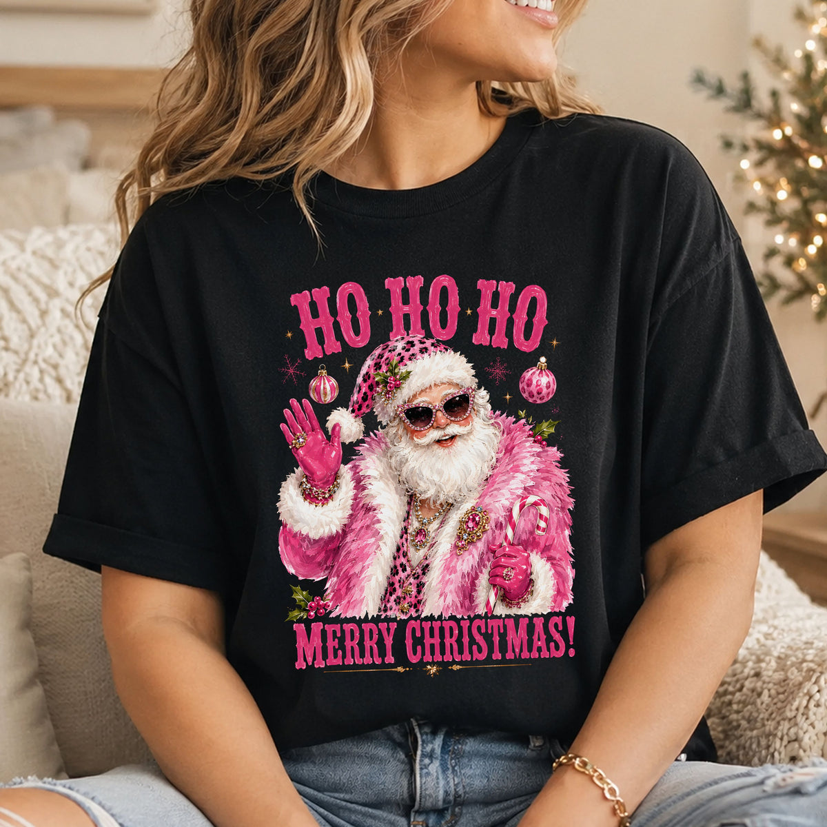 “Ho Ho Ho” and “Merry Christmas!” surround Santa in a fluffy pink coat, jeweled cat-eye sunglasses and pink gloves, waving and holding a candy cane.