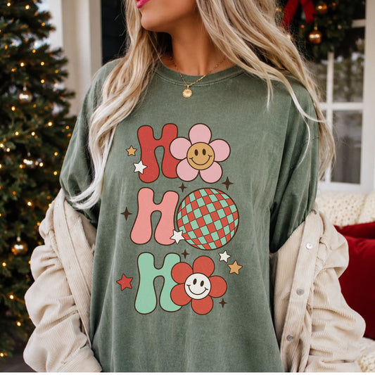 “Ho Ho Ho” stacked in red, pink and mint retro lettering, with two smiley flowers, a checkered disco ball, stars and a distressed texture.
