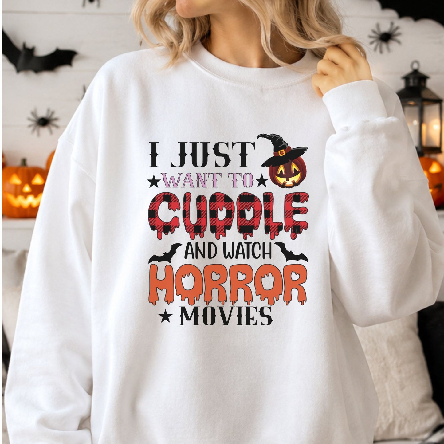 I Just Want to Cuddle and Watch Horror Movies Halloween DTF transfer featuring bold black, orange and red lettering with buffalo plaid details, dripping text, bats and a jack-o-lantern wearing a witch hat on a white sweatshirt mockup.