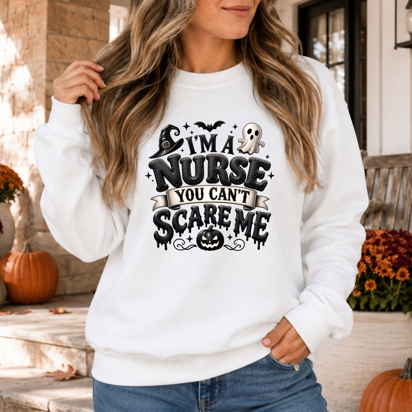Black-and-white I’m a Nurse, You Can’t Scare Me Halloween DTF transfer featuring bold dripping lettering, a witch hat, cute ghost, flying bat, sparkling stars and a jack-o-lantern on a white sweatshirt mockup.